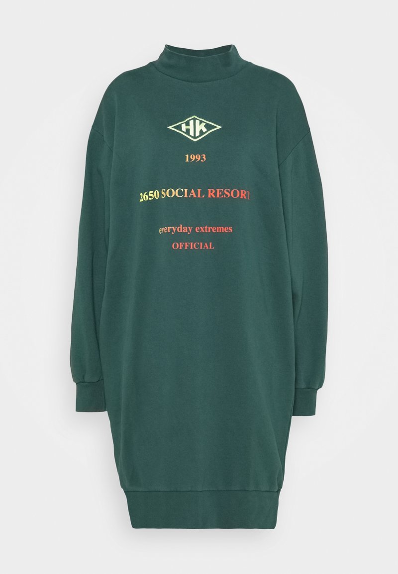 Zelené šaty s dlouhými rukávy a vysokým límcem, se žebrovanými manžetami. Obsahují text a logo v žluté a červené barvě. Měkký materiál.