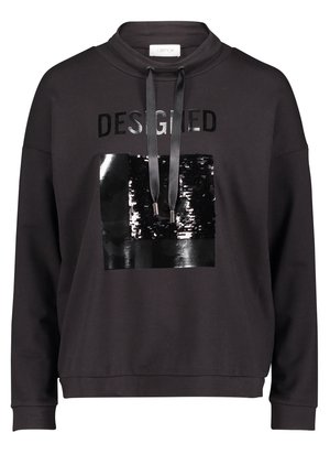 Sweat-shirt noir avec capuche à cordon, carré noir brillant à sequins, et le mot "DESIGNED" imprimé au-dessus du carré en lettres noires brillantes.