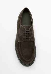 Dunkelbrauner Schnürschuh aus Wildleder mit abgerundeter Spitze, Ziernähten und kontrastierender grüner Sohle. Weiche Textur und minimalistisches Design.