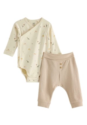 Crèmekleurig babyrompertje met lange mouwen met kleine dinosaurusprints, gecombineerd met beige geribde broek met twee knopen aan de voorkant.