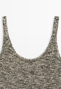 Débardeur en tricot noir et blanc avec un col rond dégagé et des bretelles épaisses, présenté sur un fond blanc.