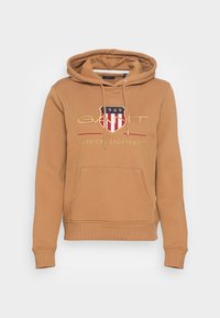 Felpa cappuccio marrone con tasca a kanga, cappuccio con lacci e logo ricamato con un design a scudo in accenti rossi, bianchi e blu.