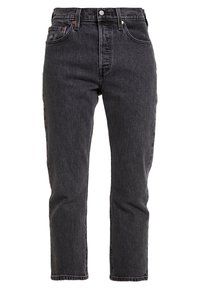 Jeans en denim noir avec une coupe droite, cinq poches et des coutures visibles. Caractéristiques de matériel en métal et d'une taille classique avec un bouton.