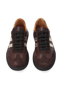 Brune ruskind sneakers har sorte snørebånd, tre metalliske striber på siderne, en afrundet tå og en tekstureret gummisål.