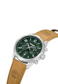 Reloj Timberland con esfera verde, caja de acero inoxidable plateado y correa de cuero marrón con logo embossado y detalles de cronógrafo.