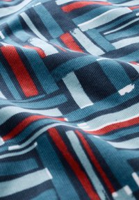 Textile fabric with a wavy texture featuring a geometric pattern of navy blue, teal, red, and white stripes in varying widths.