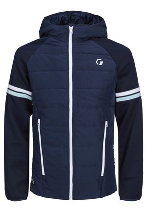 Homme portant une veste à capuche bleu marine avec une fermeture éclair blanche et des bandes sur les manches, ainsi qu'un pantalon cargo beige.