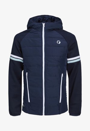 Man draagt een marineblauwe capuchonjas met witte rits en strepen op de mouwen, en beige cargobroek.
