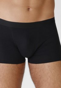Boxer briefs neri realizzati in un tessuto liscio e elastico. Presentano un colore uniforme, una cintura elastica e un design della lunghezza fino a metà coscia.
