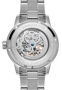 Rustfritt stål-klokke med en transparent bakside som avslører intrikate mekaniske bevegelser. Har blå detaljer og graveringer.