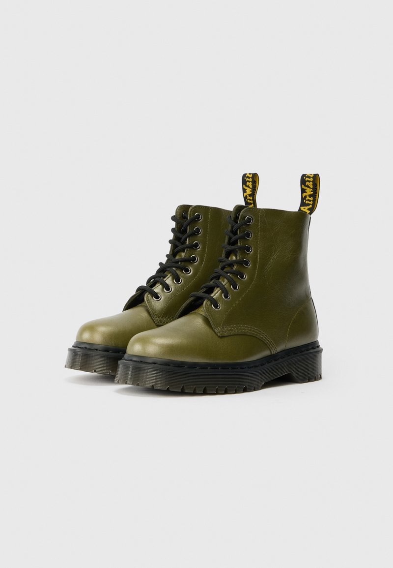 Grüne Leder-Stiefeletten mit schwarzen Schnürsenkeln, Gummisohle und gelben Zuglaschen. Sie haben eine glatte Oberfläche und ein rundes Toe-Design.