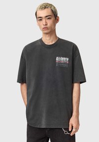 Koksgrå oversized t-shirt lavet af bomuld med rund halsudskæring. Har fronttekstlogo i kontrastfarver og ærmer med afslappet pasform.