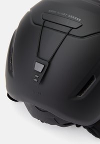 Schwarzer Helm mit mattierter Oberfläche, ausgestattet mit verstellbaren Komponenten, Belüftungsschlitzen und Branding an der Oberseite, präsentiert ein schlankes, aerodynamisches Design.