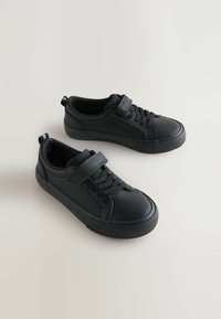 Zwarte sneakers met een glad synthetisch bovenwerk, ronde neus, vetersluiting en klittenband. Ze hebben een getextureerde rubberen zool voor grip.