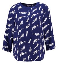 Haut bleu marine en tissu lisse avec des motifs abstraits de feuilles blanches, doté de manches trois-quarts et d'un ourlet arrondi.