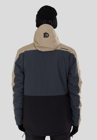 Pánská třítónová bunda s béžovým, tmavě šedým a černým blokovým designem. Obsahuje kapuci a detail loga na zadní straně.