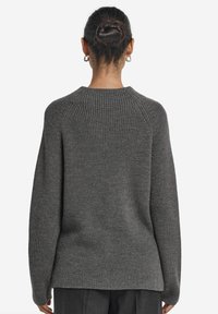 Grauer Strickpullover mit gerippter Textur, Rundhalsausschnitt und überschnittenen Schultern. Gerader Schnitt mit einem längeren Rückenbund.