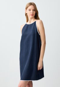 Abito di lino blu navy con bordi bianchi, design senza maniche, forma A-line, lunghezza al ginocchio, texture liscia e silhouette semplice e pulita.