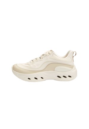 Cream-colored athletic sneaker with thick sole and ventilation holes, lace-up front, and pull tab on the heel.