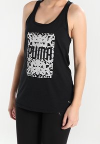 Black sleeveless tank top made from cotton, featuring a bold silver graphic print with the text "PUMA" and a textured pattern.