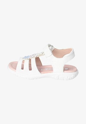 Weiße Sandalen mit geschlossener Zehenpartie und offenem Fersenbereich, ausgestattet mit durchbrochenen floralen Designelementen und einem Klettverschluss. Die weiche pinke Innensohle sorgt für Komfort.