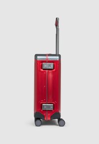 Rode hardschalenkoffer met uitschuifbare handgreep, vier wielen, combinatieslot en grijze accenten. Gestructureerd oppervlak met verticale strepen.