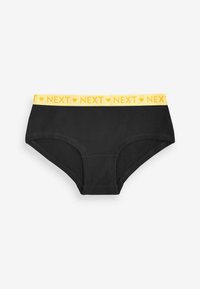Culottes en coton noir avec une ceinture élastique jaune arborant "NEXT" en texte répétitif et des graphiques en forme de coeur. Design basique, style hipster.