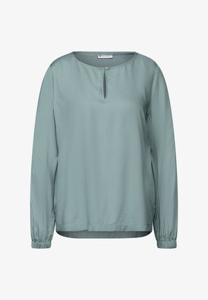 Jasnozielona bluzka z długim rękawem o okrągłym dekolcie i małym otworze w kształcie klucza. Posiada elastyczne mankiety oraz miękką, gładką teksturę.