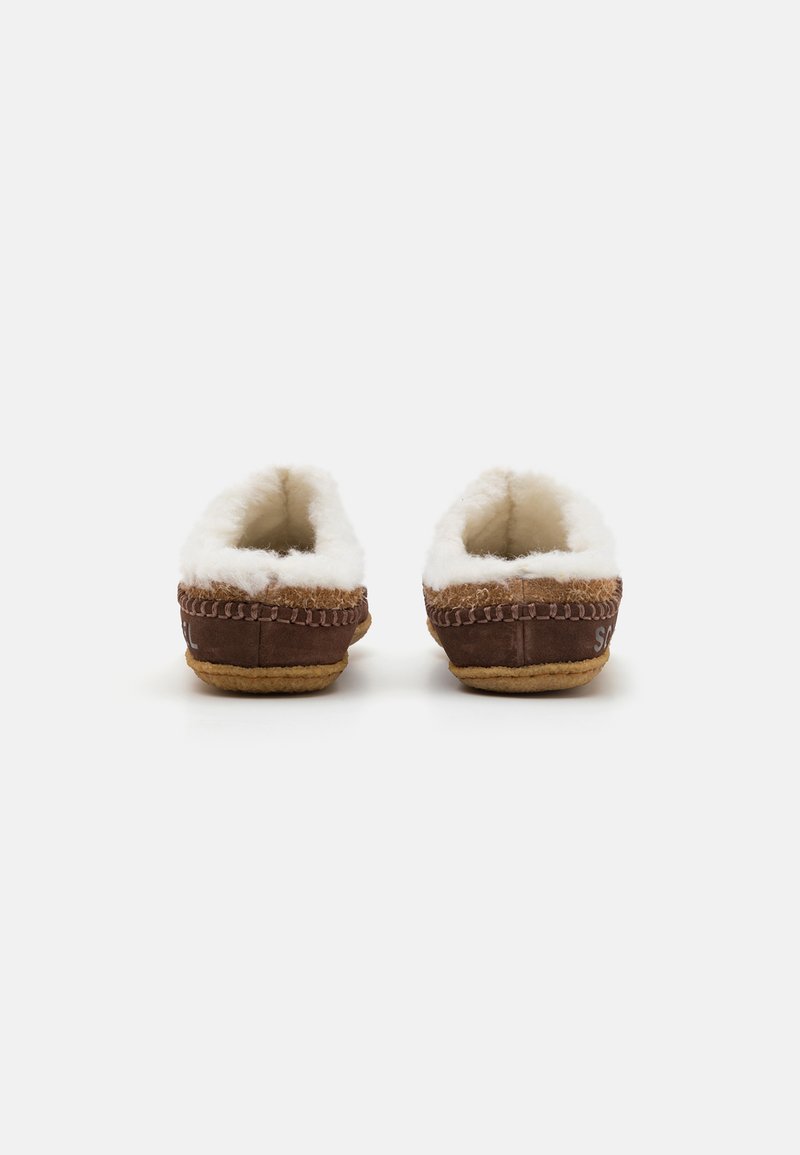 Bruine suède slippers met witte fleece voering, ronde neus en beige rubberen zool. Heeft contrasterende stiksels langs de bovenrand.
