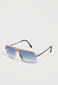 Gafas de sol aviador con montura crema y franja de acento roja, que presentan lentes azules degradados y brazos metálicos negros.