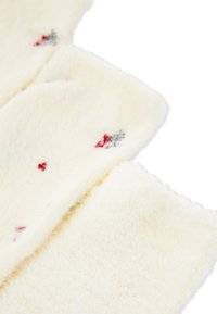 Szalik z polaru w kolorze kremowym o miękkiej, teksturowanej powierzchni; zdobią go małe czerwone i szare wzory kwiatowe.