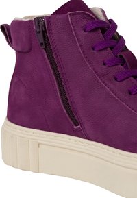 Fioletowy, wysoki sneaker wykonany z teksturowanego zamszu, z boku zip, okrągłymi sznurowadłami i kontrastującą białą gumową podeszwą.