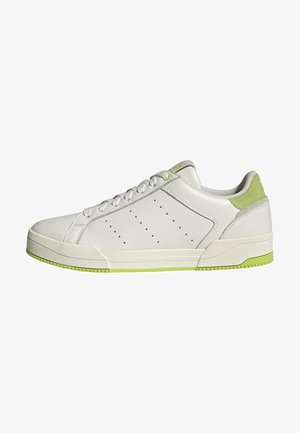 Biały niski sneaker z jasnozielonymi akcentami na pięcie i podeszwie, perforowanymi detalami bocznymi oraz białymi sznurówkami.