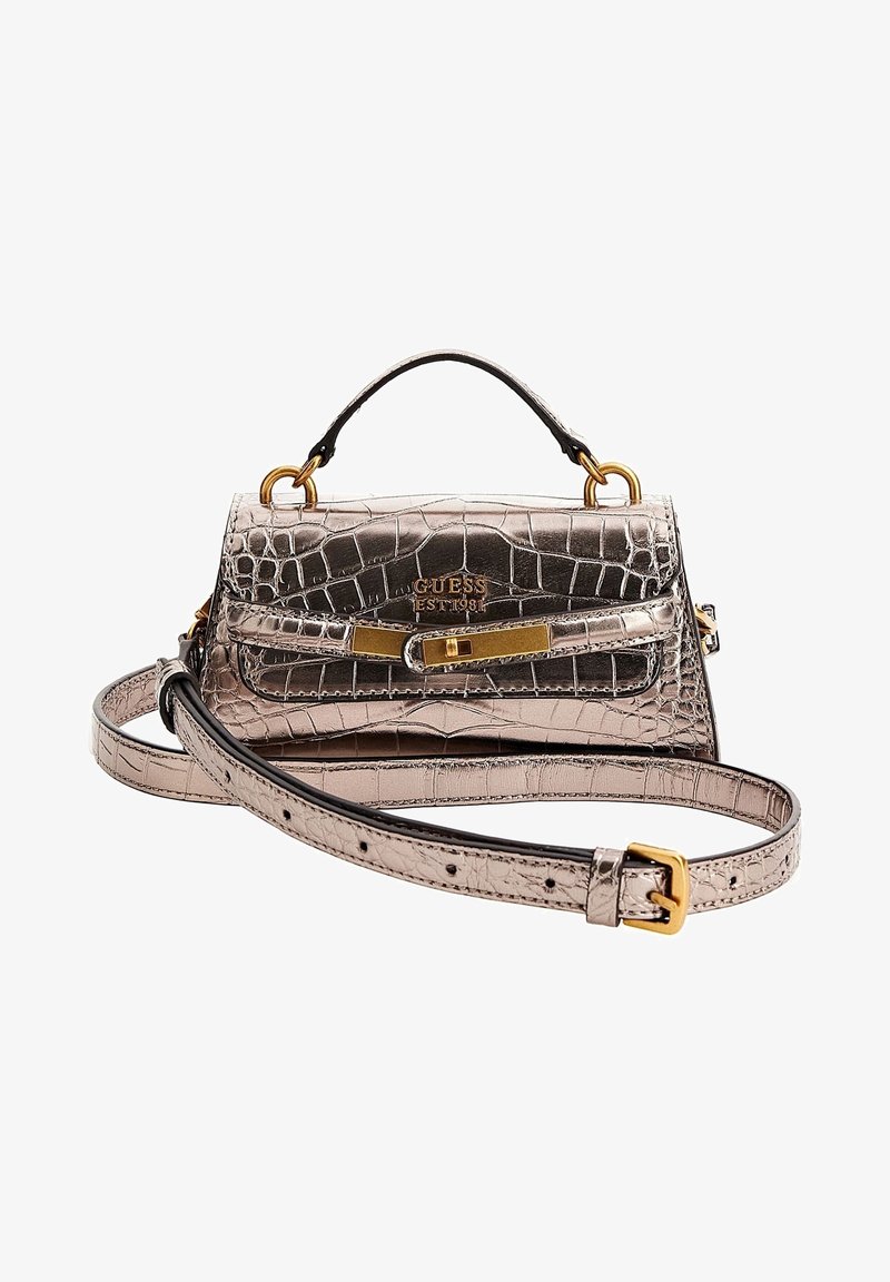 Sac à main Guess métallisé or rose embossé crocodile, avec poignée supérieure, bandoulière amovible et fermeture dorée.