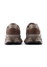 Καστανά αθλητικά παπούτσια με υλικά από δίχτυ, σουέντ και καουτσούκ. Διαθέτουν μαλακή σόλα, στρογγυλεμένο σχέδιο και διακριτικές λεπτομέρειες με λογότυπο.
