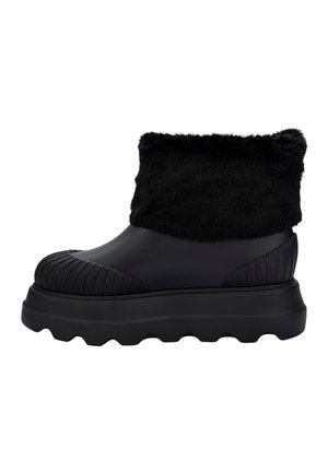 Black waterproof ankle boot, featuring a faux fur cuff, ribbed texture on the toe, and a chunky sole with a wavy tread pattern.