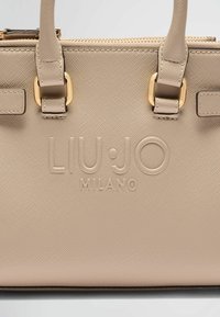Sac à main en cuir beige avec une finition texturée, doté de quincaillerie dorée, de doubles poignées et d'un logo "LIU·JO MILANO" embossé à l'avant.