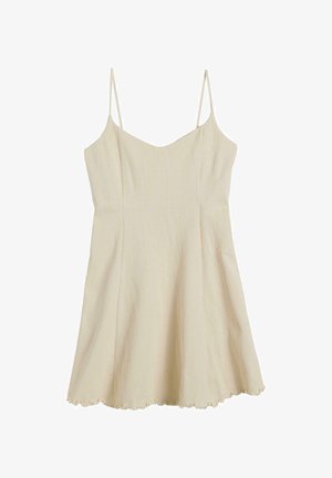 Light beige slip dress with spaghetti straps, featuring a textured wavy pattern and a scalloped hem. Smooth fabric, relaxed silhouette.