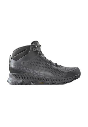 Scarpa da trekking alta nera con suola strutturata, tomaia in mesh, chiusura con lacci e marchio La Sportiva sul lato.