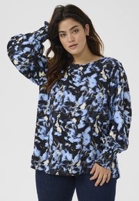 Mustertakakäega must blouse sinise ja kreemja abstraktse mustriga. Pehme kangas, elastsete varrukate ja ümmarguse kaelusega.