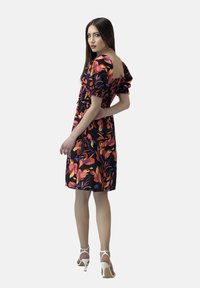 Vestido negro con vibrantes patrones florales en naranja, rosa y púrpura. Presenta mangas abullonadas y un corsé ajustado con una falda acampanada.