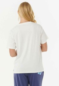 Camiseta de algodón blanca con mangas cortas y escote redondo. Presenta un diseño simple sin patrones ni adornos visibles.