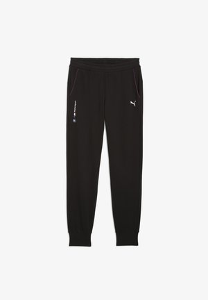 Pantalons de jogging noirs en tissu lisse avec taille élastique, poches latérales zippées et coutures contrastantes mauves. Présente le logo Puma.