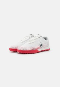 White athletic shoes with a textured upper, red gradient detailing, a round toe, and a black logo on the side; rubber outsole for traction.