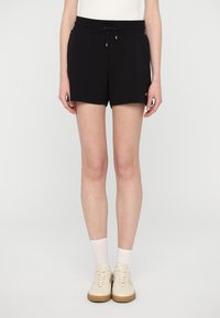 Pantalones cortos negros con una cinturilla elástica y cordón ajustable, que incluyen un pequeño detalle de logo. Hechos de una tela suave, diseñados para comodidad y facilidad.