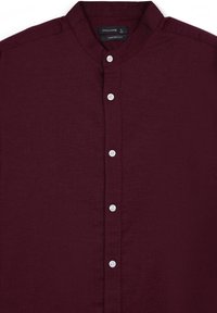 Camicia bordeaux con colletto a band, dotata di pattina frontale e cinque bottoni bianchi. Realizzata in un morbido tessuto testurizzato in una vestibilità comoda.