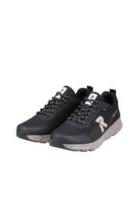 Black athletic shoes with a textured upper, contrasting beige accents, speckled sole, and reflective laces. Designed for comfort and support.