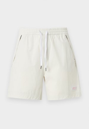 Shorts blancs à taille élastique avec cordon, poches latérales et petit logo brodé près de l'ourlet gauche.