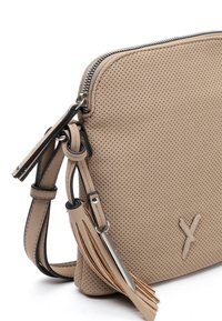 Borsa in pelle beige perforata con chiusura a zip, tracolla regolabile e dettaglio con nappina sui lati. Forma rettangolare piatta con dettagli in hardware a contrasto.