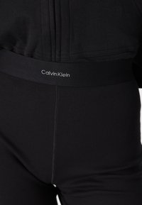 Svarta Calvin Klein leggings med ribbad textur och ett brett midjeband som har märkesnamnet broderat i vitt.